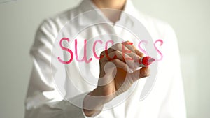 Woman writing Success on transparent screen. Businesswoman write on board
