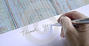 Woman writing thank you on card or paper