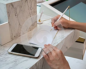 Woman writing on a white sheet of paper. Business woman hand si