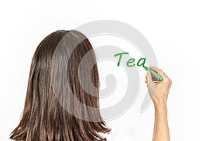 Woman writing the word Tea on a white background with a green marker