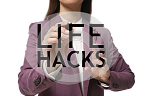 Woman writing words Life Hacks on glass board against white background, closeup