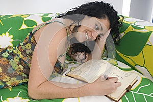 woman writting a notebook sitting on an armchair photo