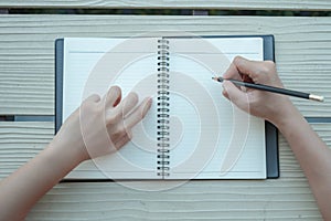 The woman wrote the book with a clay book in a yellow background. The top view