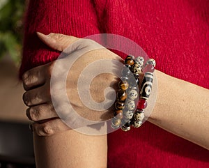 A woman& x27;s hand with Bracelets from jasper and obsidian and tiger eye stones.
