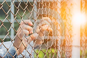 Woman's hand caught an iron cage in Places of Detention to await freedom. Light Fair.