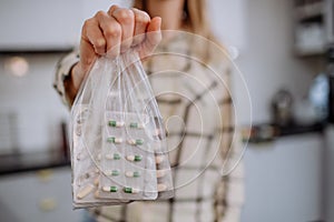 Woman& x27;s hand holding expired pills ready to recycle. photo