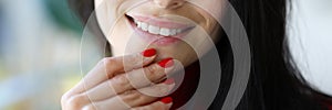 Woman& x27;s smile and fingers with red nails