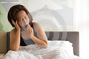 Woman yawning on bed.