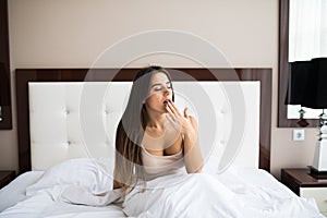 woman yawning in bed at home