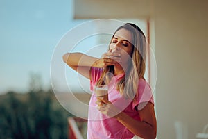 Woman Yawning Holding a Cold Coffee in a Glass
