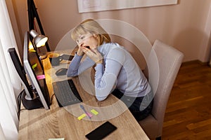 Woman yawning while working in an office