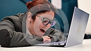 The woman yawns and falls asleep on a laptop at desk in the office