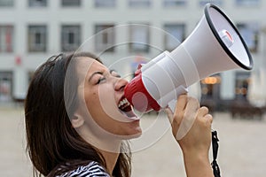 Woman yelling into a bullhorn on an urban street