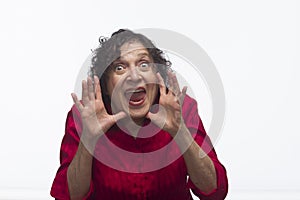 Woman yelling between hands, horizontal