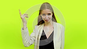 Woman yellow background twisting her index finger in space studio