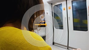 Woman in yellow blouse getting home train, monotony lifestyle, public transport