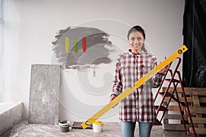 Woman with yellow bubble level tool. Human holding building and engineering measure equipment.