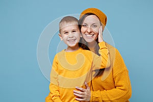 Woman in yellow clothes have fun posing with cute child baby boy 4-5 years old. Mommy little kid son isolated on blue photo