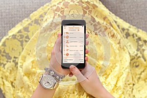 Woman yellow dress holding phone app tracking delivery package