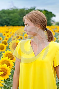 Woman in yellow dress in sunflower field