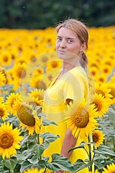 Woman in yellow dress in sunflower field