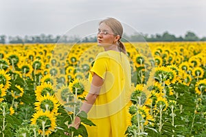 Woman in yellow dress in sunflower field