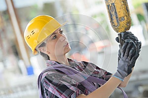 Woman in yellow helmet working on building site