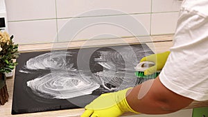 Woman in yellow household gloves open lid of kitchen hood and take out dirty ventilation mesh then close. Housewife