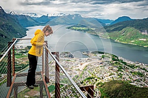 Woman in yellow jacket looking on Andalsnes city from rampestreken