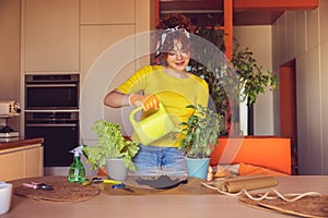 Una mujer en plantando a regando plantas 
