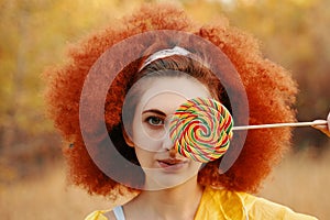 Woman in a yellow raincoat with big Lollipop