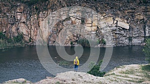 Woman in yellow raincoat hiking in the mountains