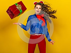 Woman on yellow with red present box jumping