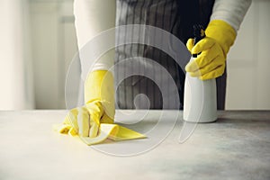 Woman in yellow rubber protective gloves wiping dust and dirty. Cleaning concept, banner, copy space