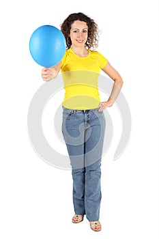 Woman in yellow shirt and jeans offers balloon