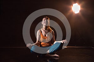 Woman in a yellow t-shirt in a dark Studio illuminated by colored spotlights