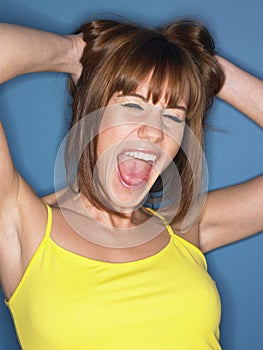 Woman In Yellow Tank Top Screaming With Hands In Hair