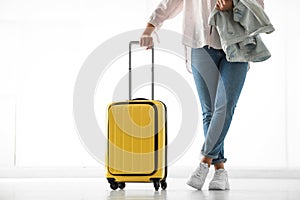 Woman with yellow travel suitcase in airport