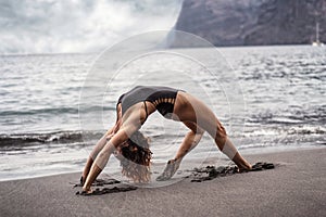 Woman in yoga pose on the beach. Slim women practicing ,balancing. Ideal fit body. Morning routine. Yoga retreat. Healthy
