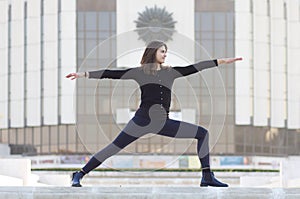 Woman in yoga pose in city