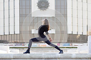 Woman in yoga pose in city