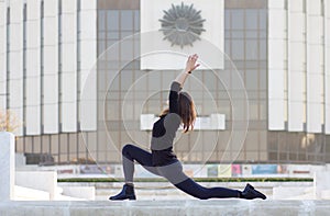 Woman in yoga pose in city