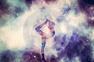 Woman in yoga pose meditation on nebula galaxy background