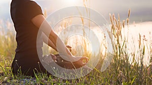 Woman with yoga posture on the mountain at sunset.