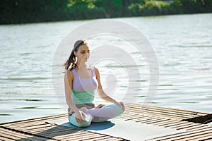 Woman Yoga - relax in nature. Caucasian woman yoga on the bridge, meditating in yoga pose at a mountain stream.