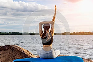 Woman Yoga sitting  near river  nature sunset