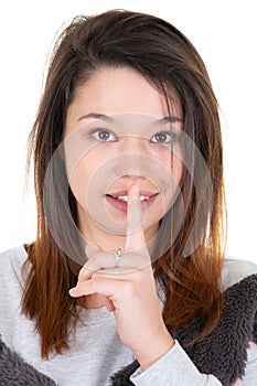 Woman young asking for silence or secrecy with finger on lips shh hand gesture white background wall