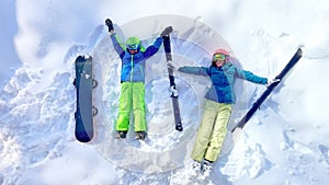 Woman and young boy with snowboard in ski outfit view from above