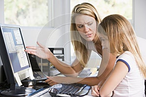 Woman and young girl in office with computer