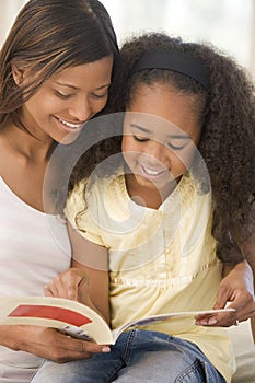 Woman and young girl sitting in living room